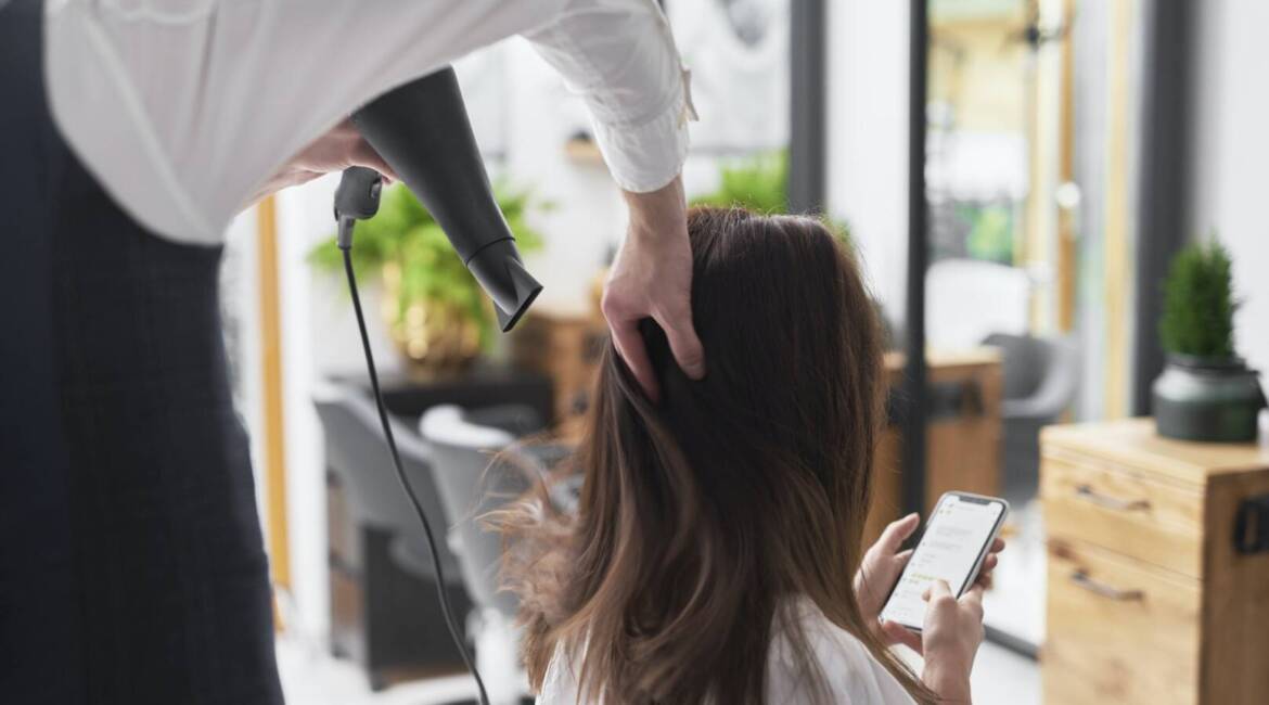 Close up of hairdresser using hair dryer